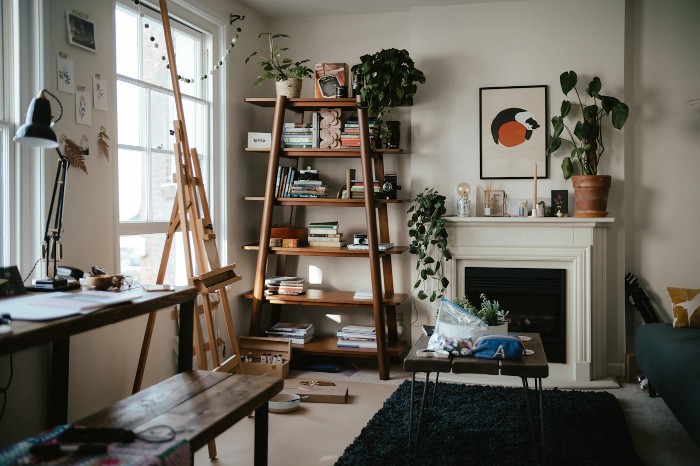 Comfortable lounge with armchairs, shelving and a lit fireplace